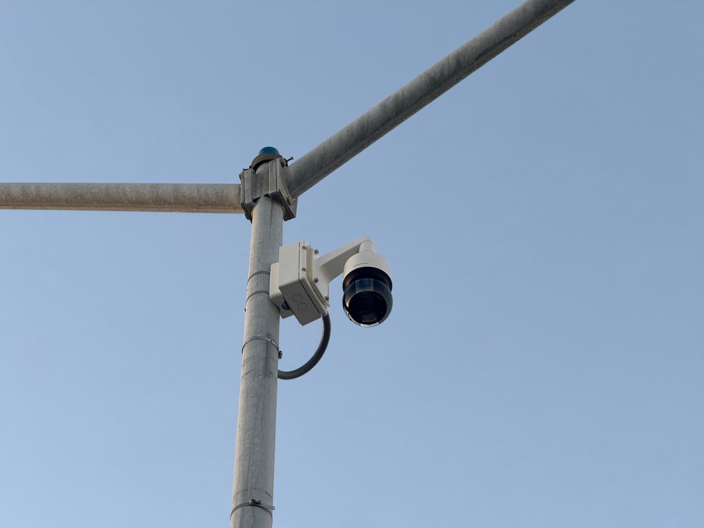 Pole-mounted commercial security camera on an exterior metal post