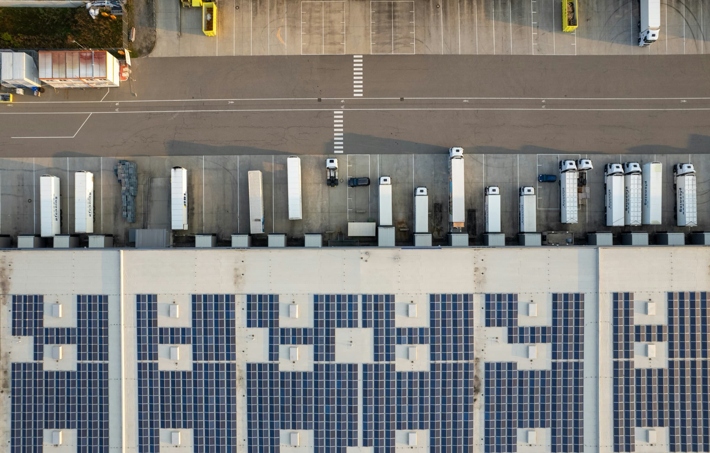 Aerial view of a commercial logistics warehouse yard with trailers and loading lanes