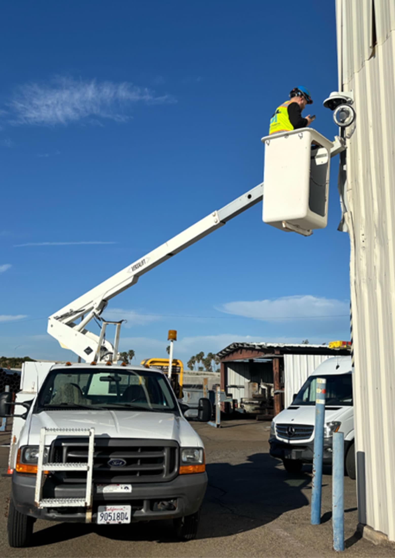 Bezemer Industries technician installing a commercial security camera from a lift