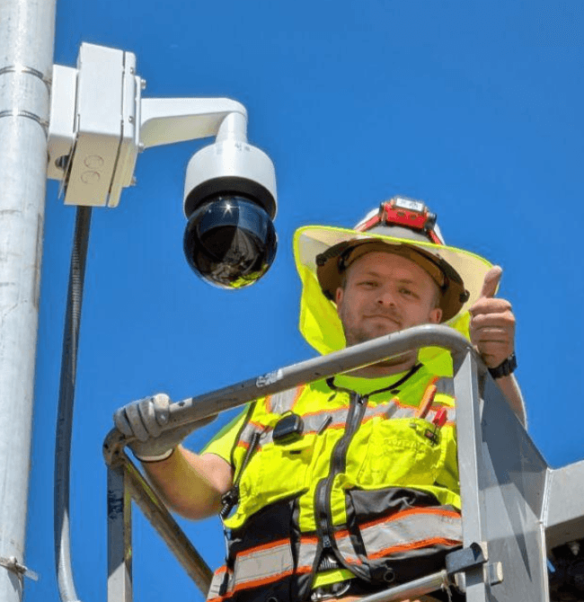 Bezemer Industries technician installing a commercial security camera from a lift in Clovis, CA